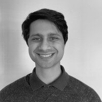 Smiling person in a gray sweater portrait.