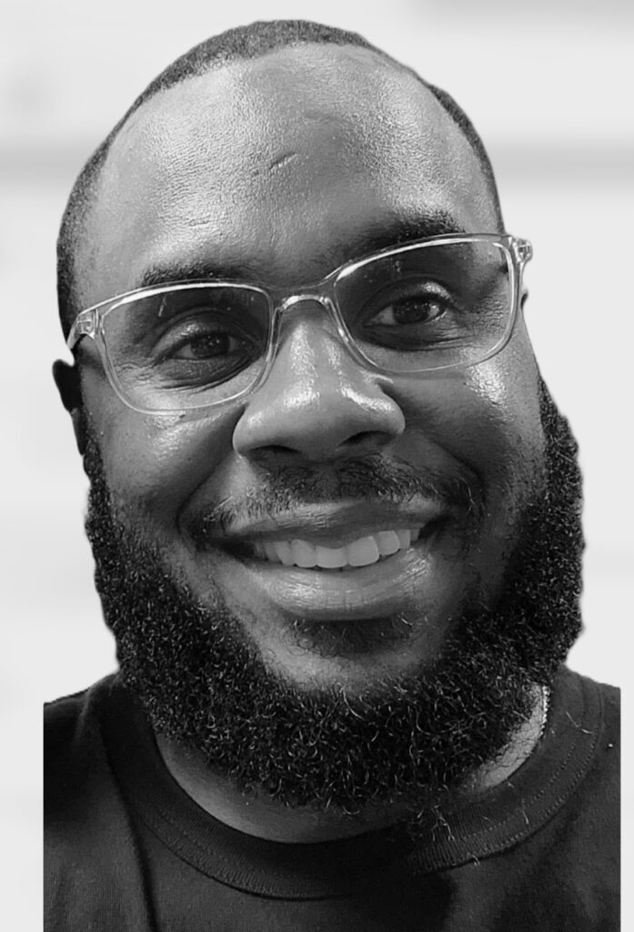 Smiling man with glasses and a beard.